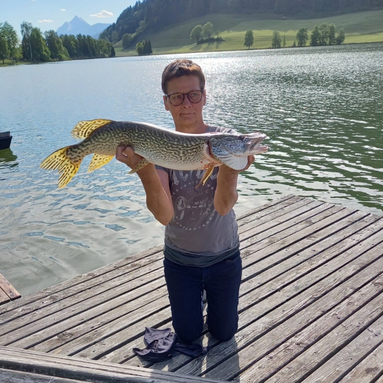 Manuela Altmüller poses with her freshly caught pike in front of the Putterersee.