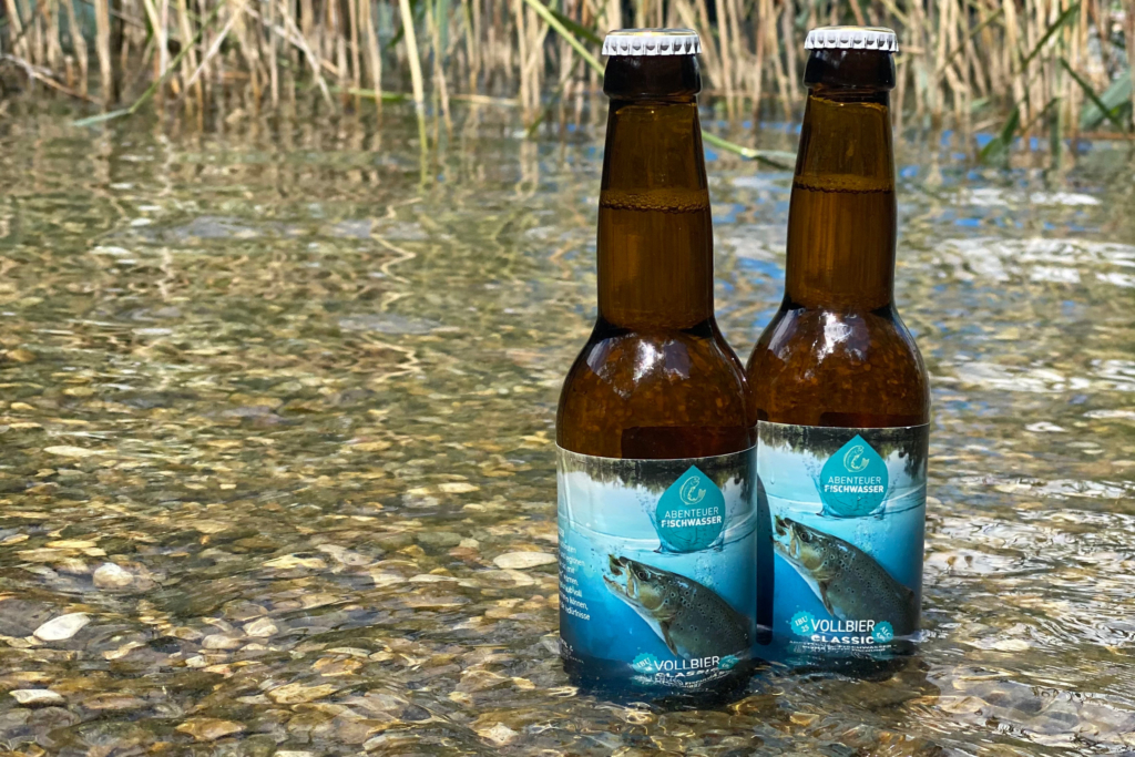 Das ABENTEUER FISCHWASSER Bier, gebraut von der Biermanufaktur Loncium, in kühlem Gewässer.